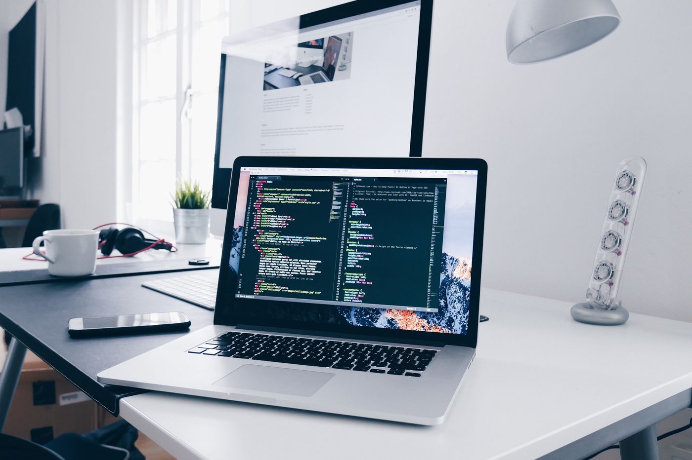 Portátil com o código de um site numa secretária